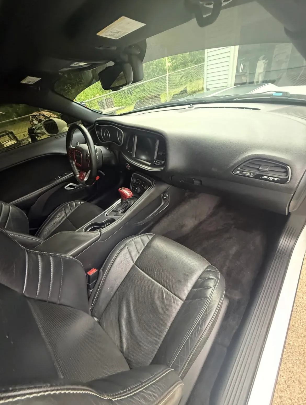 Passenger side of a Dodge Challenger SRT after detailing, with clean leather seats, dashboard and carpet.